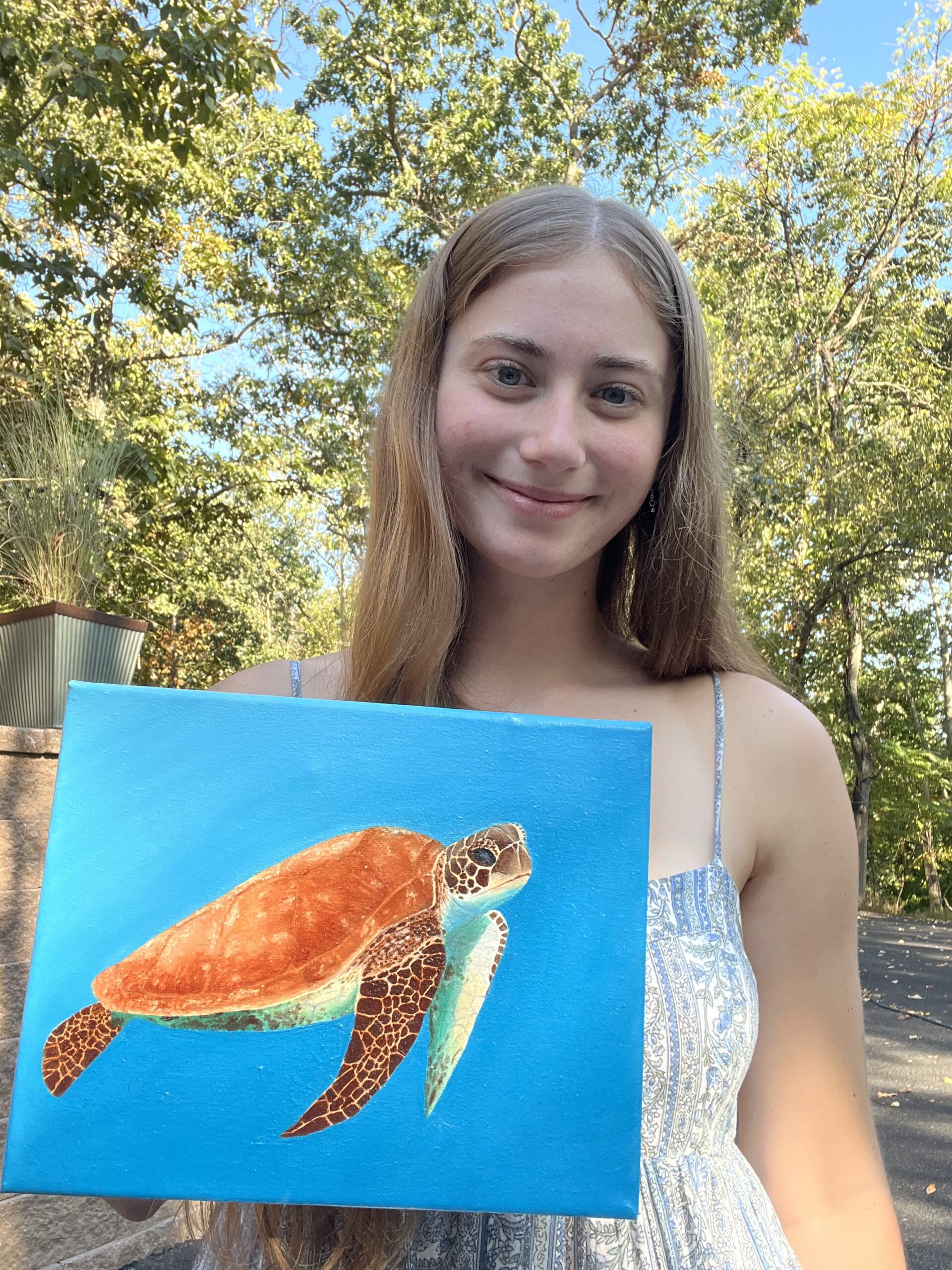 Artist holding a realistic sea turtle oil painting in blue ocean water on canvas